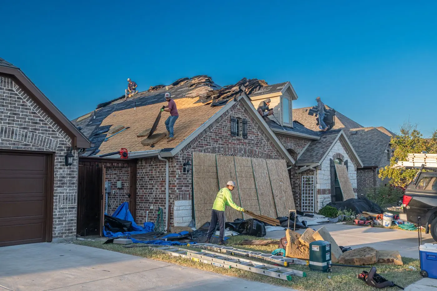 Werkers op het dak van een woonhuis tijdens een dakreparatie
